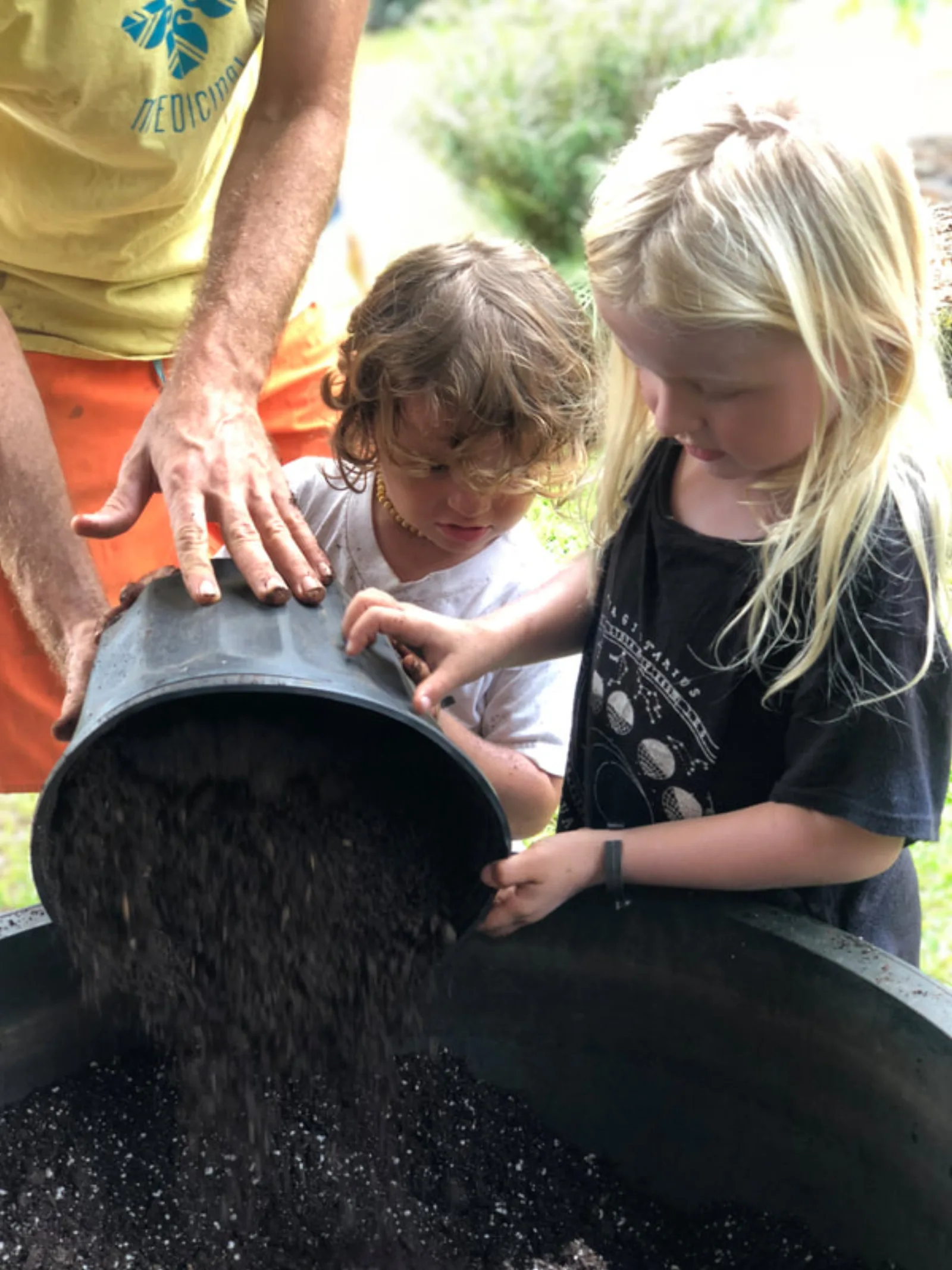 Children mixing soil together during a Yogarden field trip